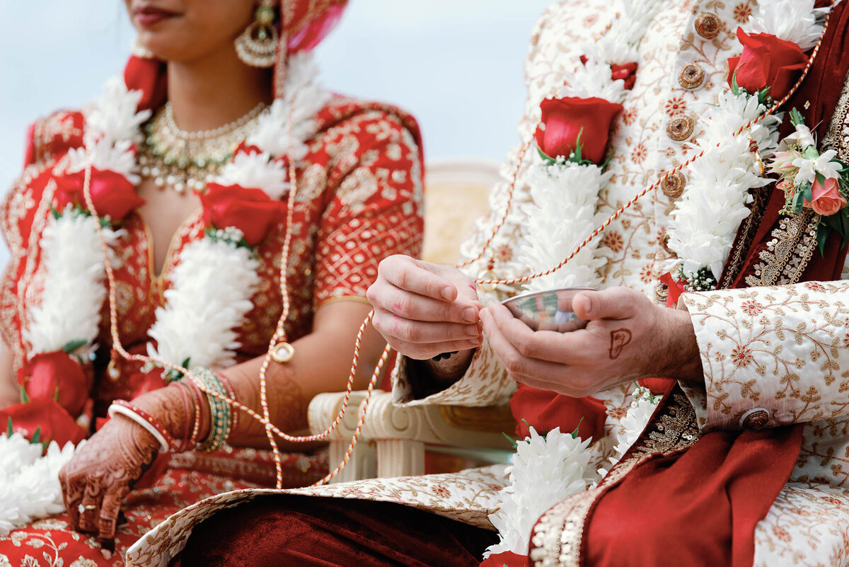 detail of indian groom holding flowers for ceremony at brick house shelburne museum wedding