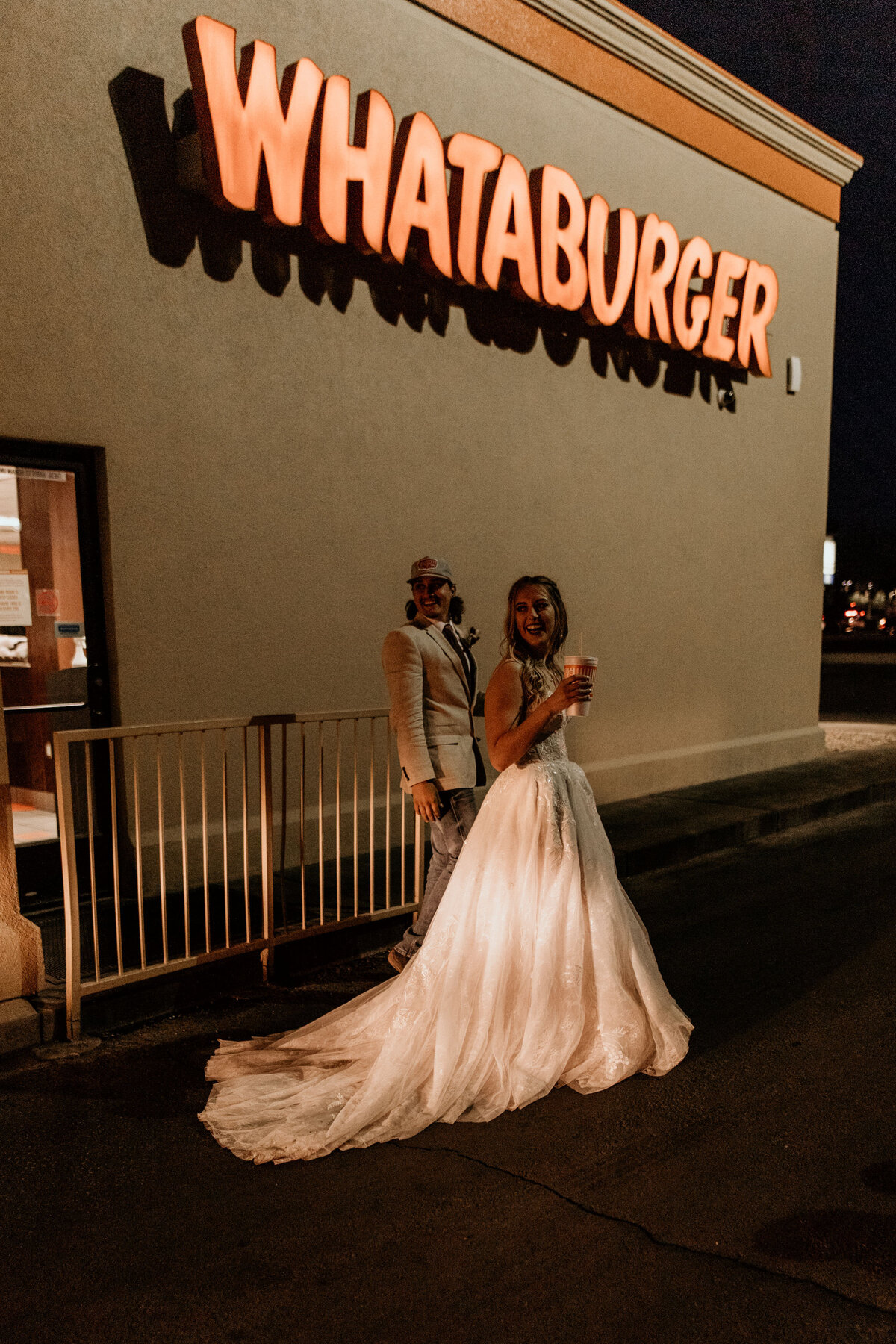bride and groom ordering food in wedding attire at Whataburger drive thru