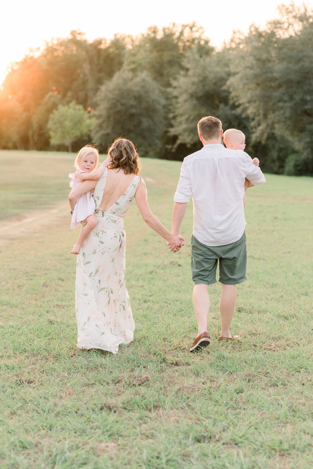 parents walking while holding their two small kids