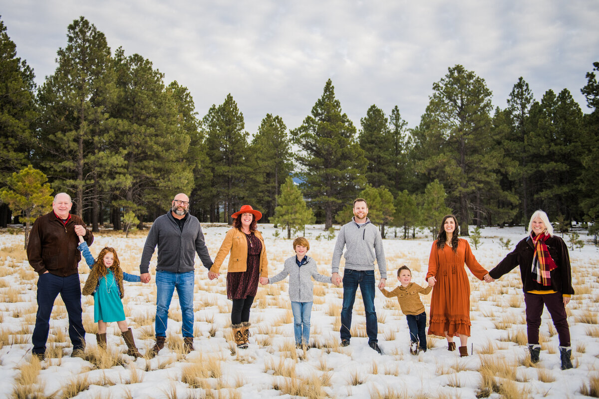 Flagstaff family holding hands in snow winter pine trees Flagstaff Kendrick Park photography Arizona