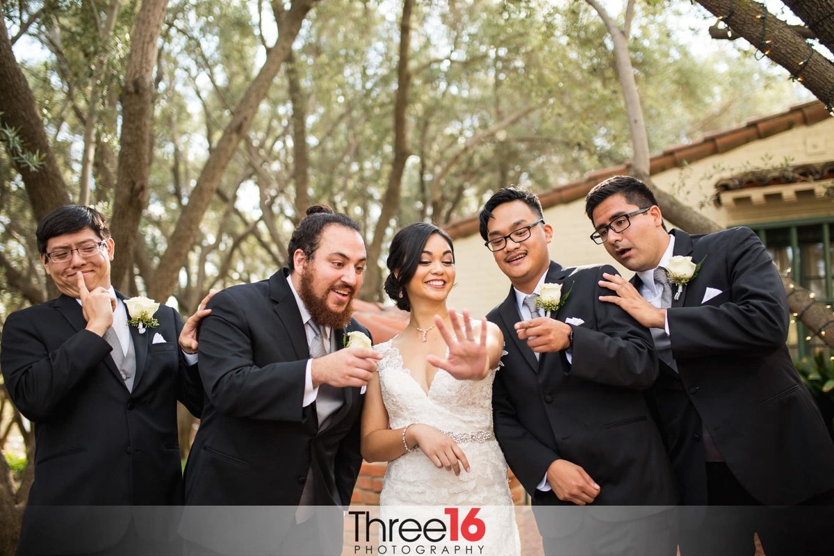 Bride flashes the groomsmen the beautiful wedding ring on her finger after the ceremony