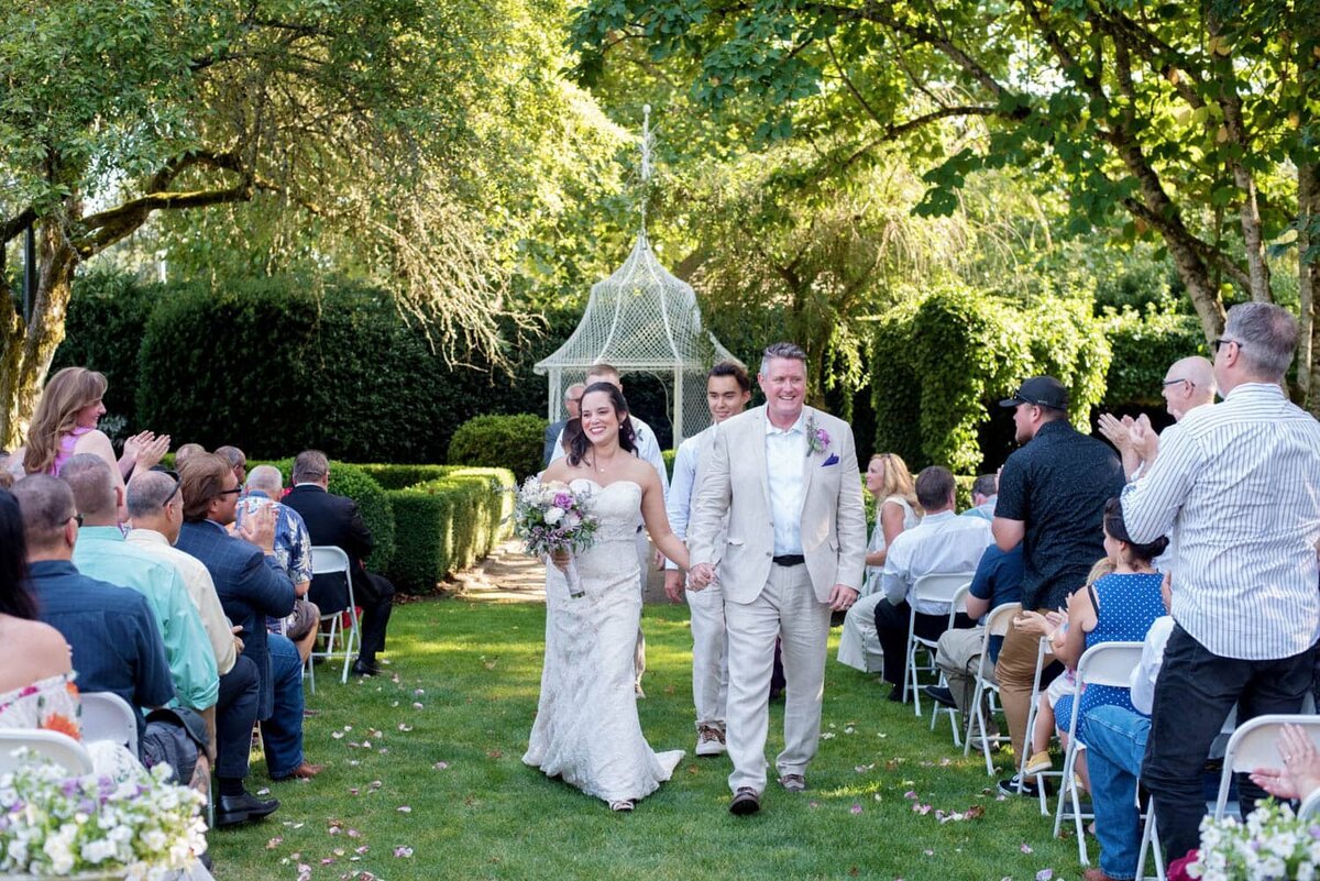 a bride and groom exit their wedding ceremony in front of the gazebo at deepwood