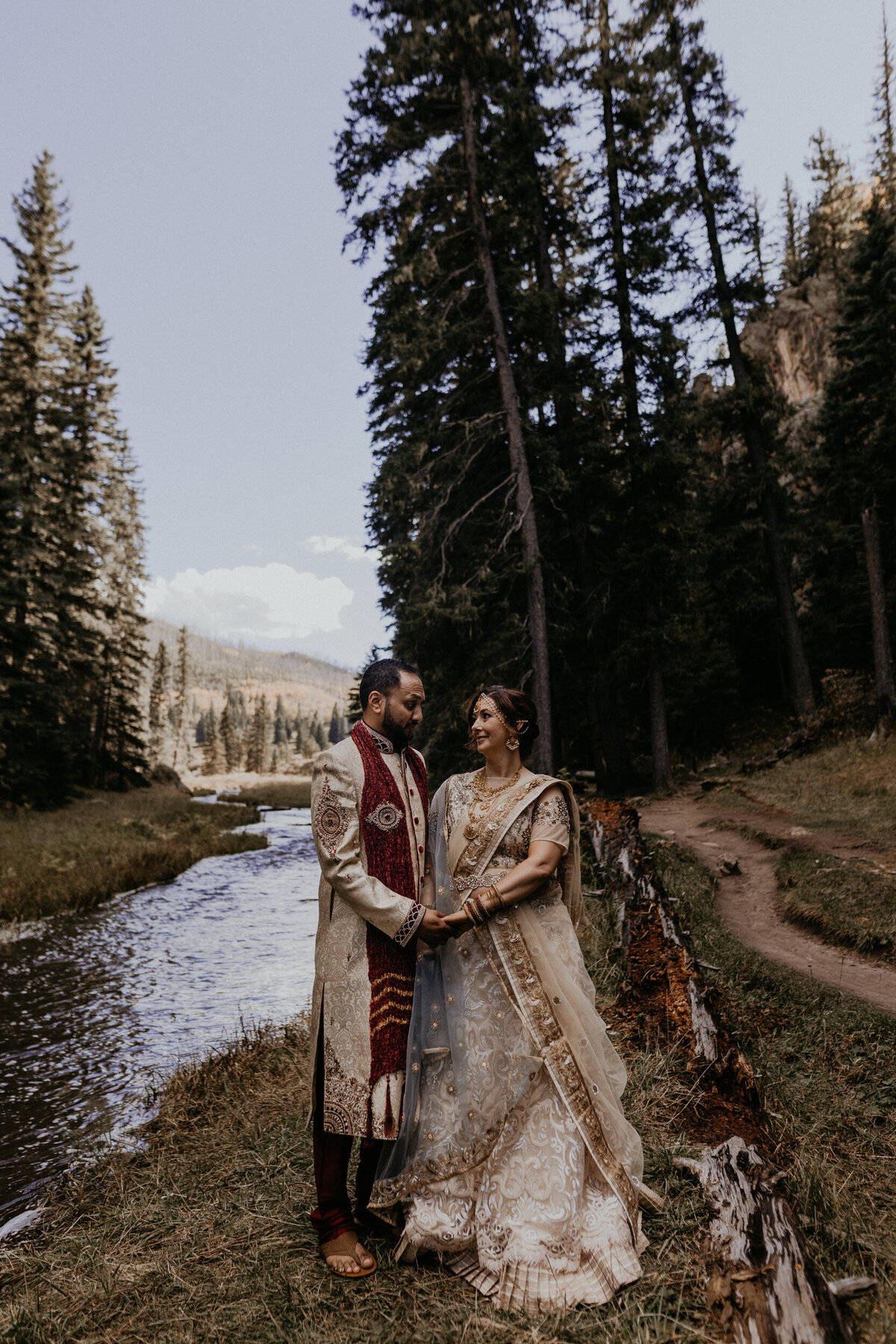 bride and groom standing together in front of a creek in New Mexico