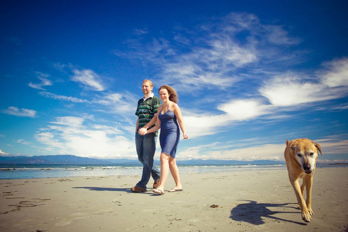 couple holding hands on Parksville Beach with their dog