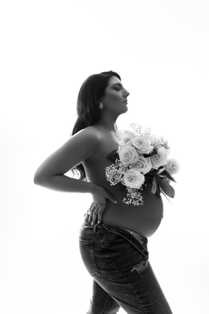 Side profile of pregnant belly with flowers across chest, by best maternity photographer nj
