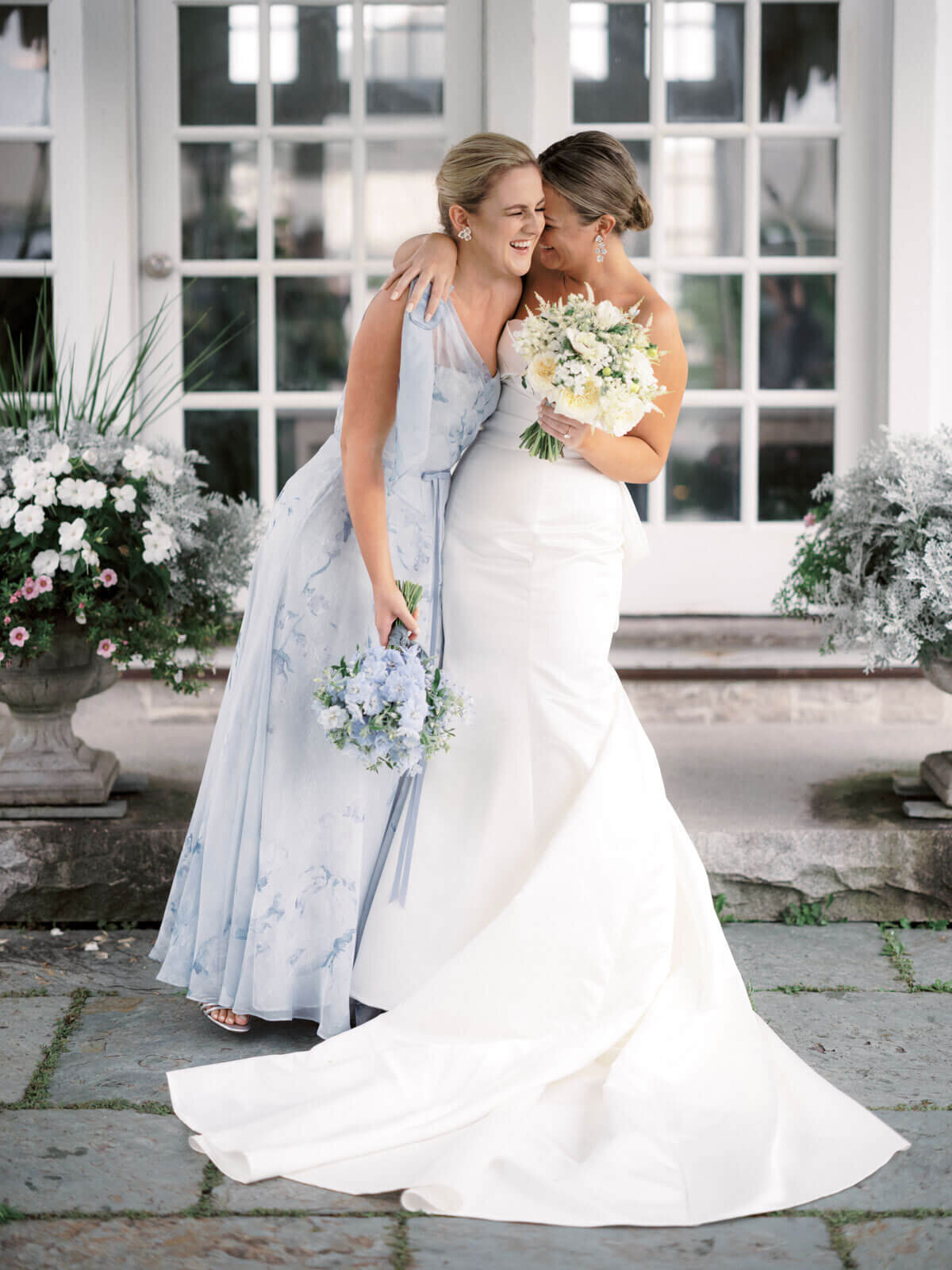 The bride and her maid of honor are happily hugging each other at The Lion Rock Farm, Sharon, CT. Image by Jenny Fu Studio
