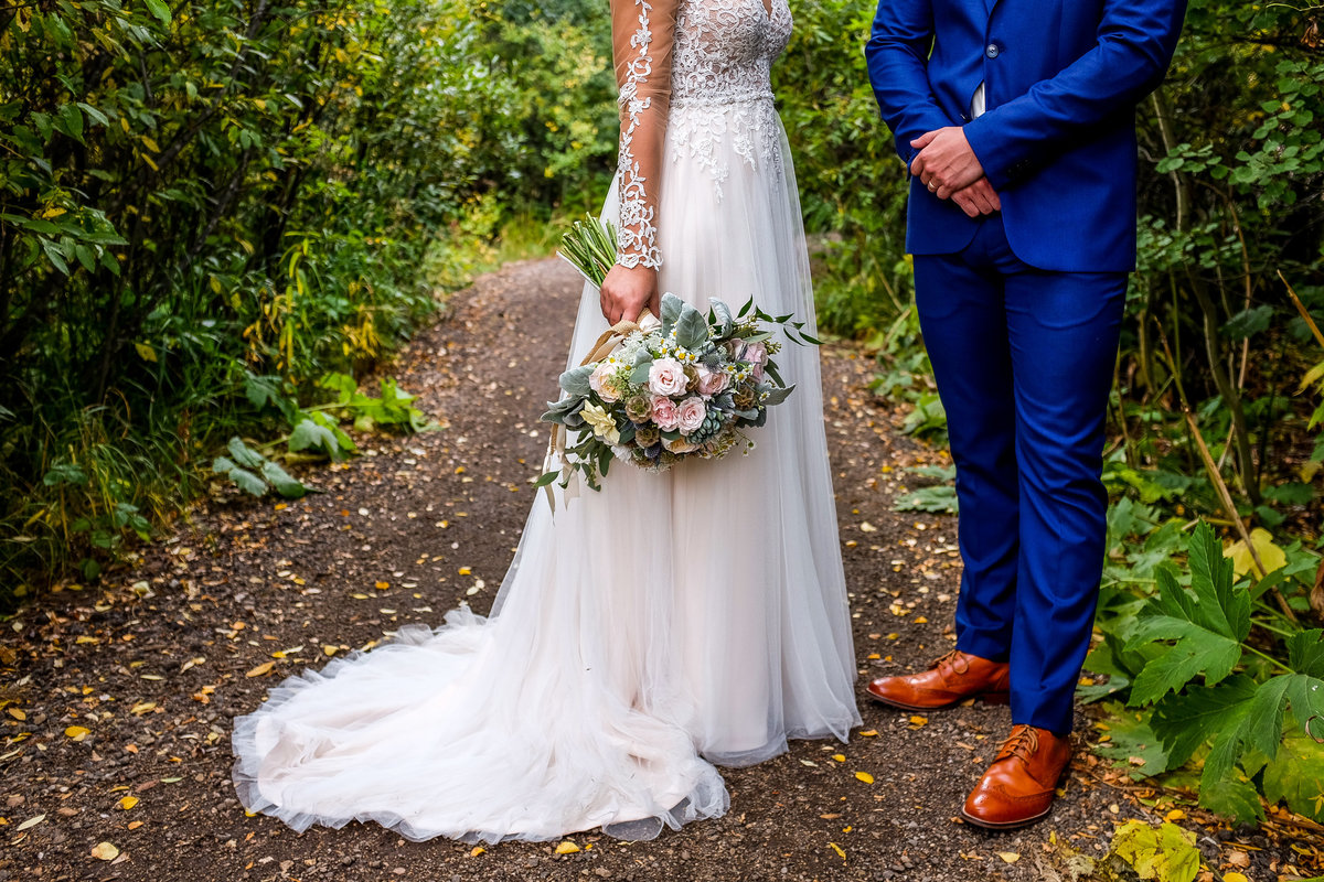 bride and groom in a forest trail