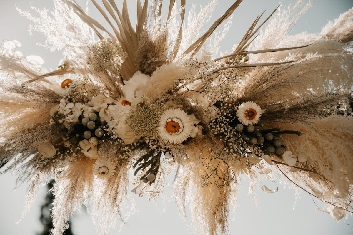 Boho inspired ceremony floral installation by Moonlight Flowers, trendy and lush floral shop located in Sparwood, BC featured on the Brontë Bride Vendor Guide.