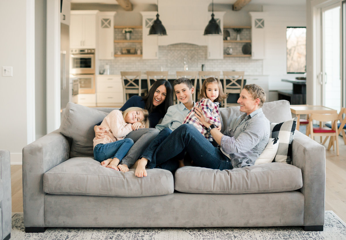 in home lifestyle family photography of everyone cuddling on a couch