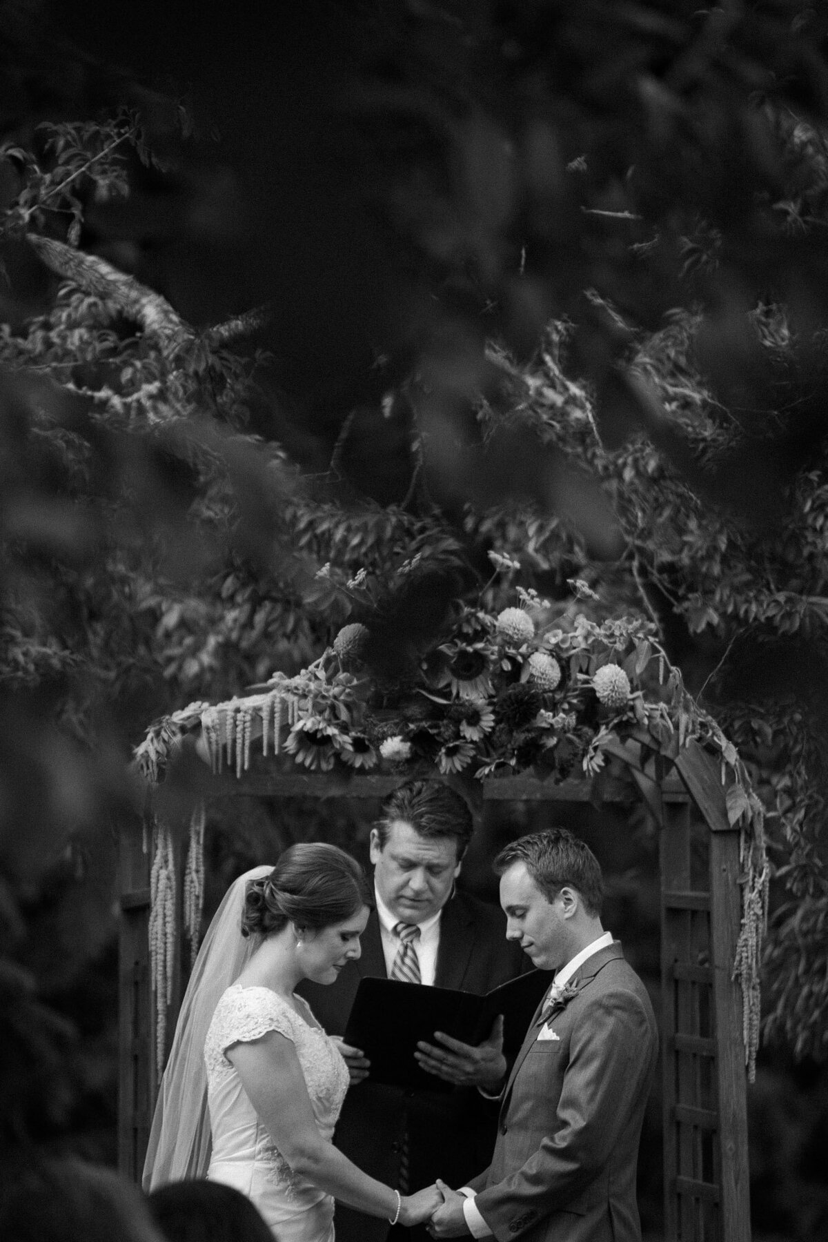 Bride-and-groom-exchange-vows-at-emotional-wedding-ceremony-in-forest-in-Woodinville-WA-photo-by-Joanna-Monger-Photography