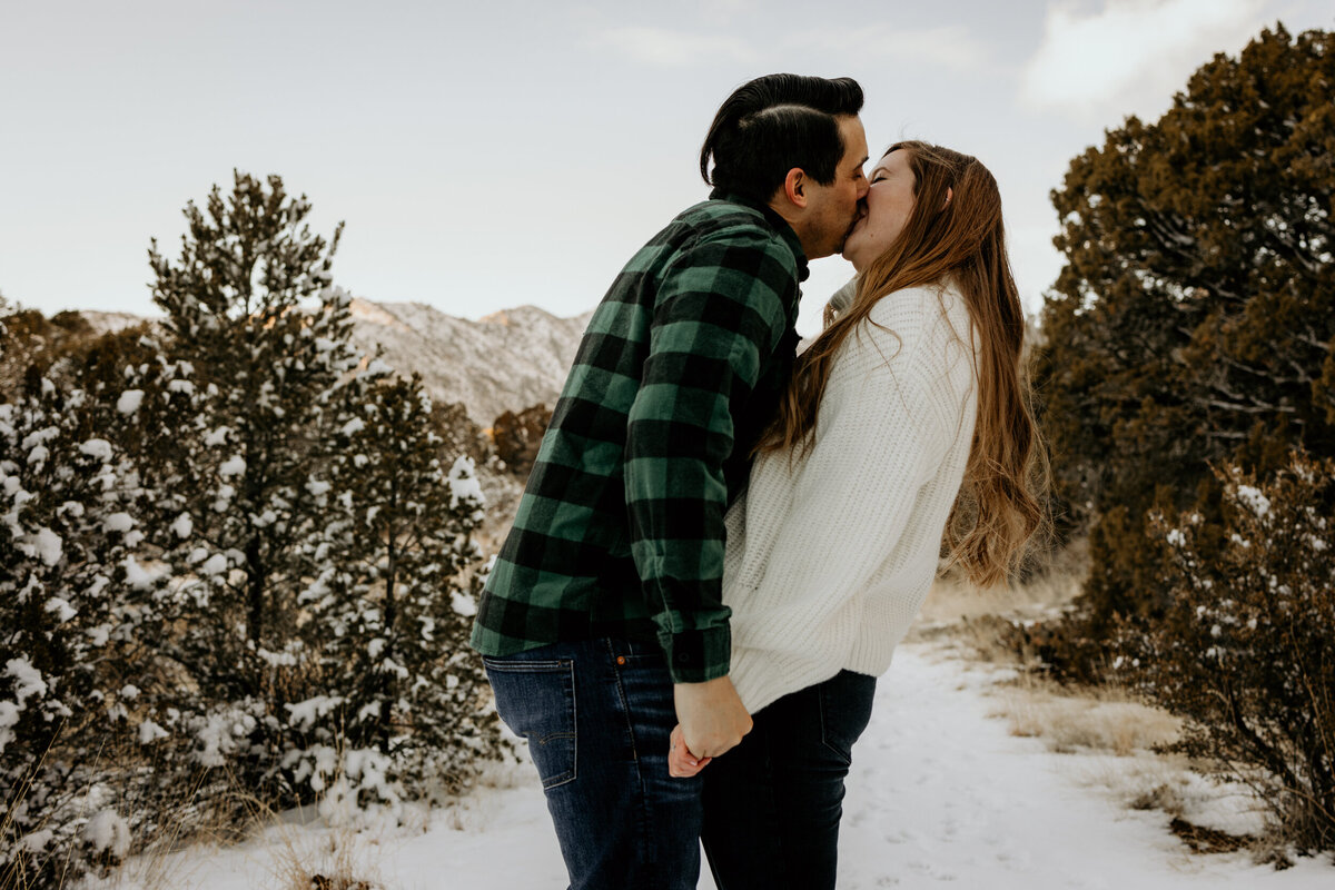 couple kissing on the  snowy Sandia foothills in Albuquerque