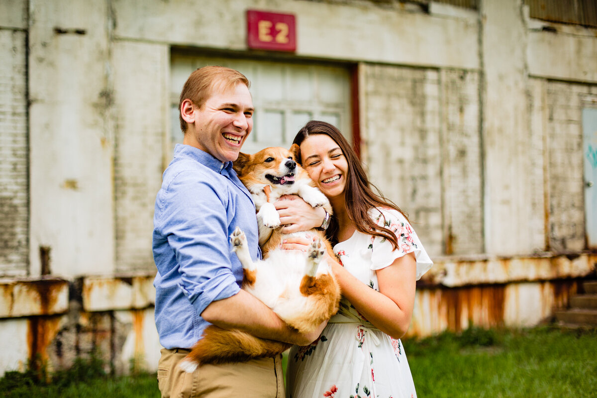 A couple holds their dog during their engagement photos in toledo ohio.  Photo By Adore Wedding Photography. Toledo Wedding Photographers