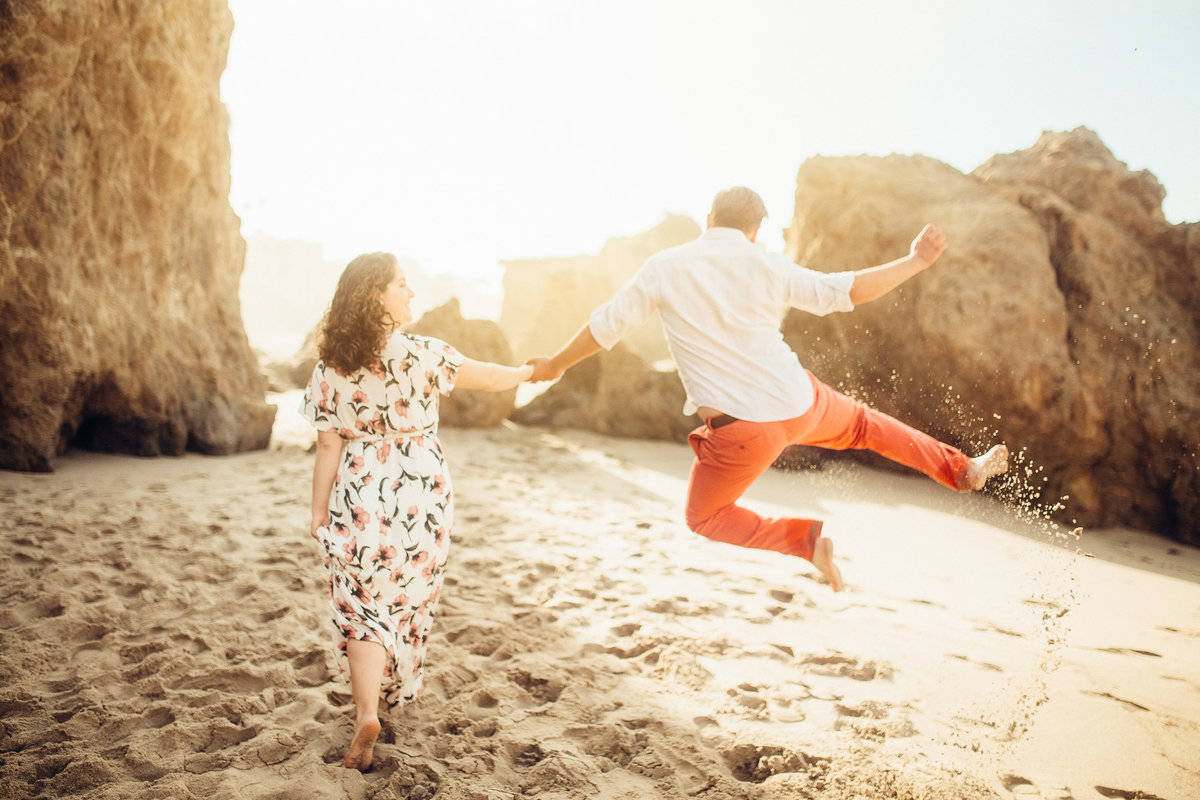 Engagement Photograph Of  Man Jumping While Holding Hands With a Woman Los Angeles