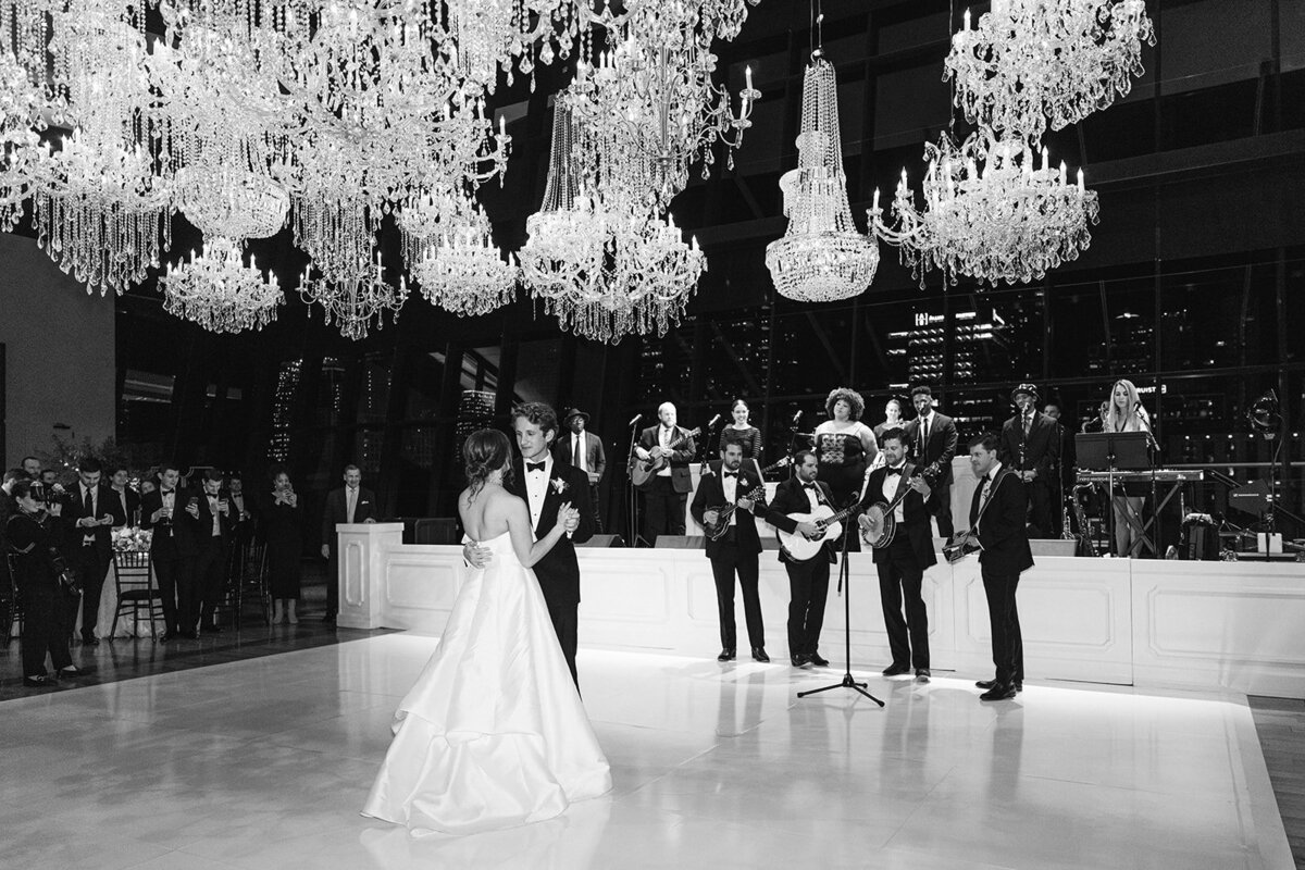 bride and groom first dance under chandeliers