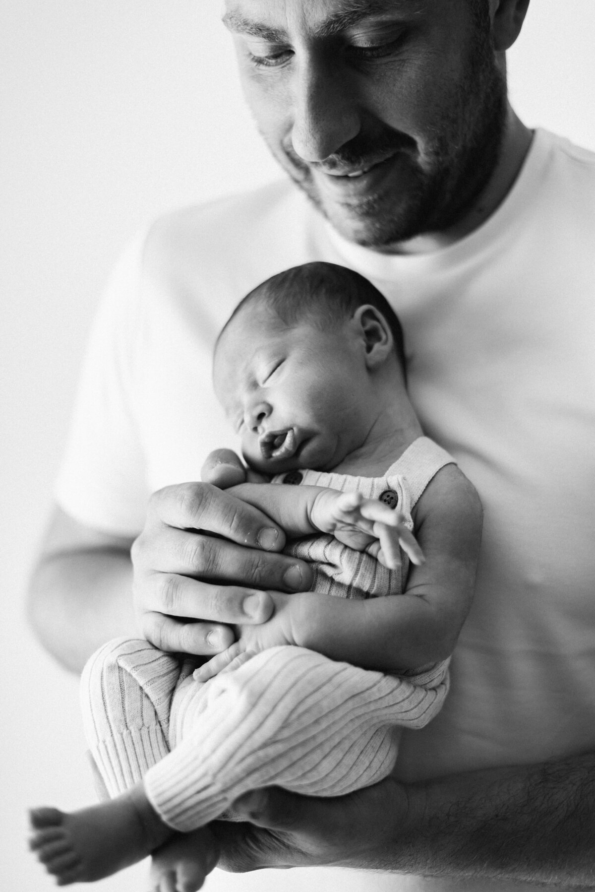 Dad holding newborn baby during a photoshoot in billingshurst