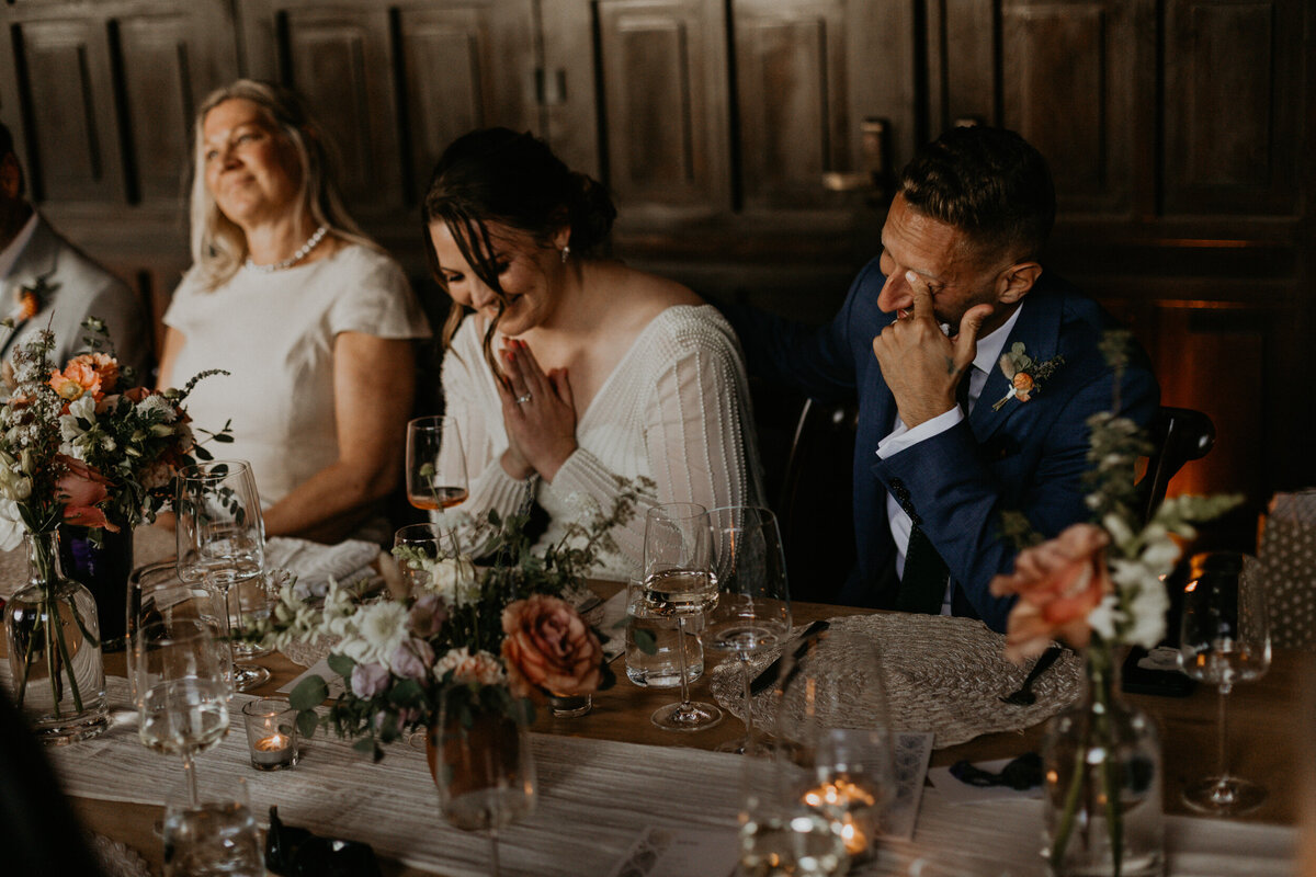 emotional shot of speeches at a newlyweds intimate wedding reception dinner