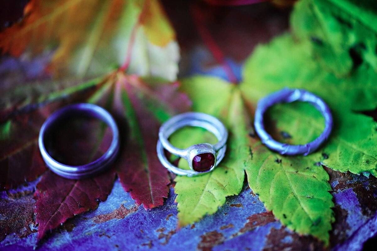 engagement duck tape rings and saphire wedding ring on fall leaves during wedding