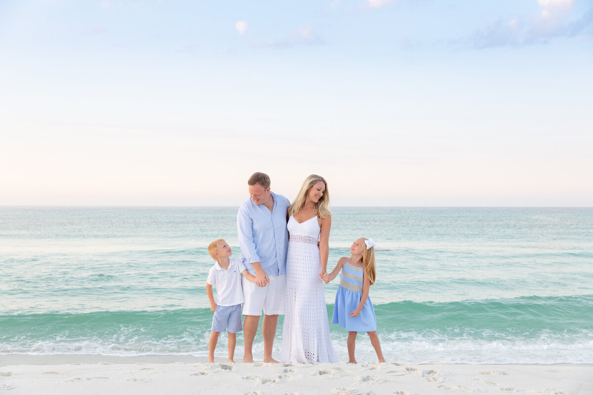 Two kids standing on either side of their parents smiling