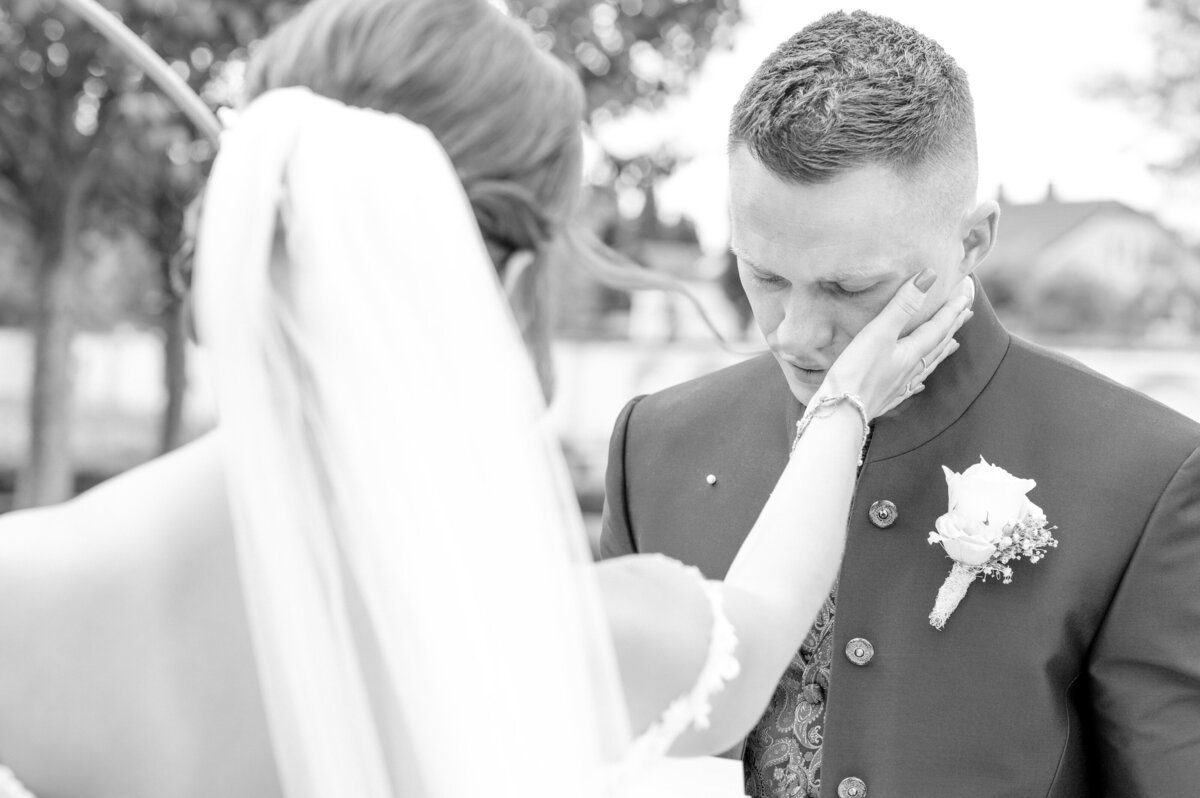 Braut berührt Bräutigam während der Gelübde Hochzeitsfotograf Starnberg