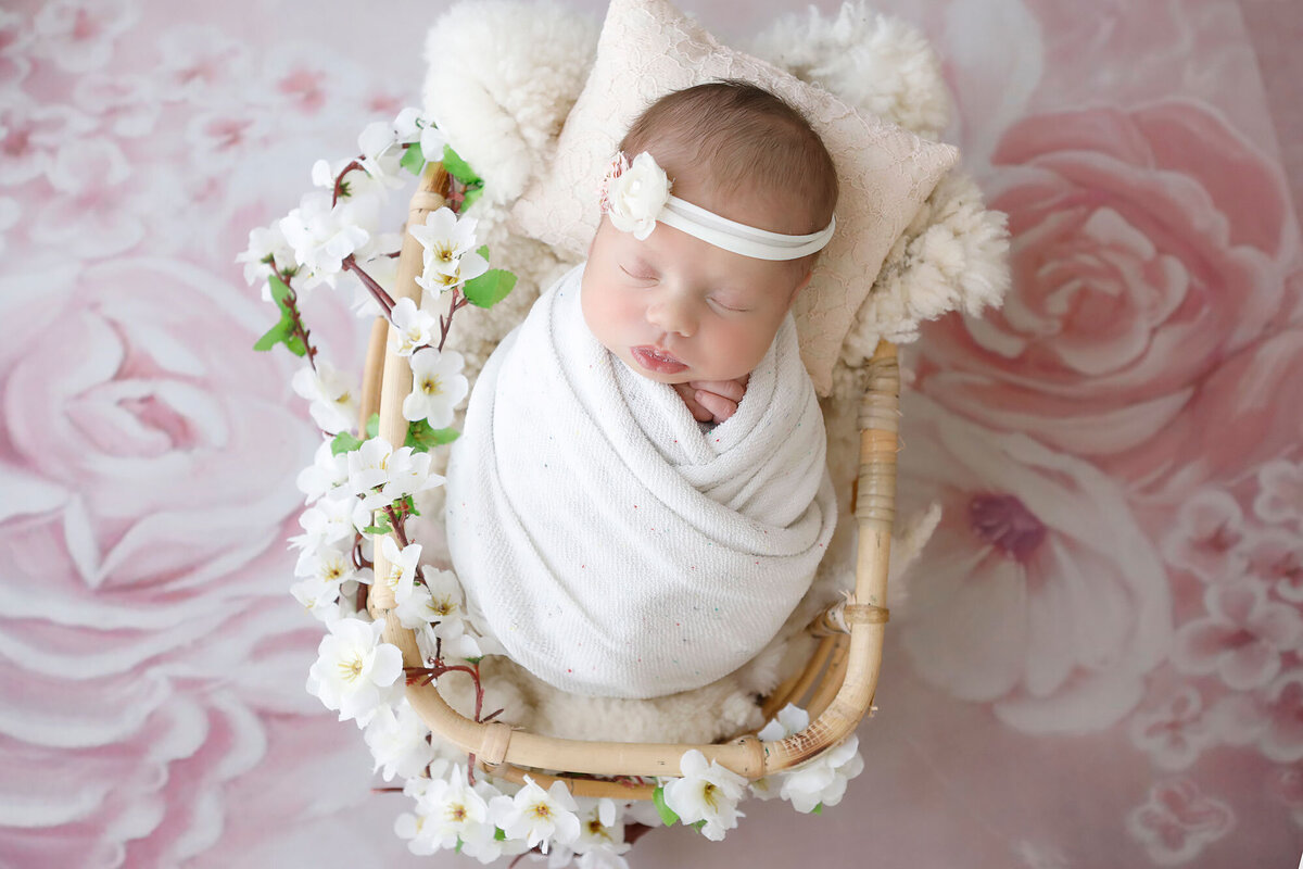 baby-girl-sleeping-in-a-bamboo-basket-wrapped-in-a-white-wrap