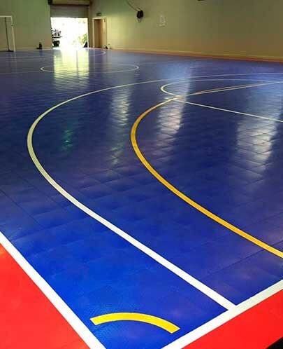 An indoor basketball court with blue and red lines markings.