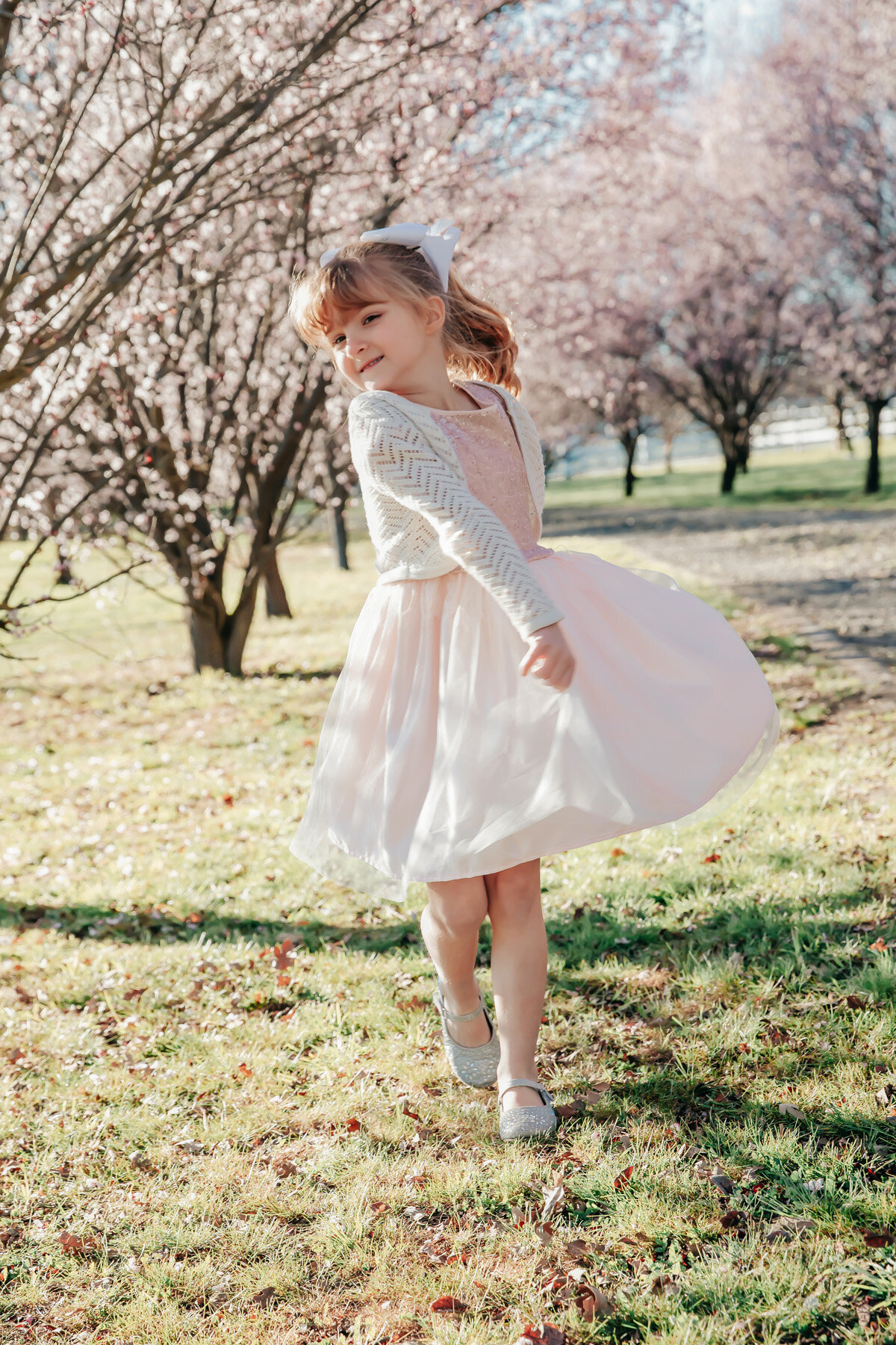 little girl running in cherry blossoms