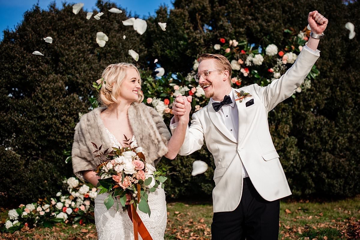1920s theme winter wedding with  bride and groom standing in front of the large floral installation