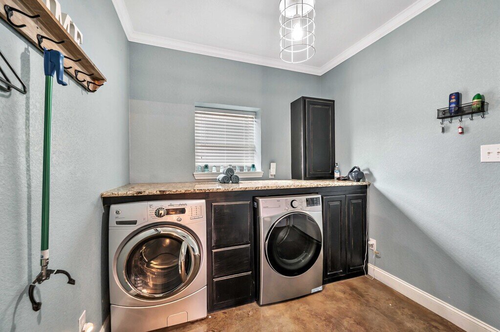Laundry room with washer and dryer in this four-bedroom, four-bathroom vacation rental home and guest house with free WiFi, fully equipped kitchen, firepit and room for 10 in Waco, TX.