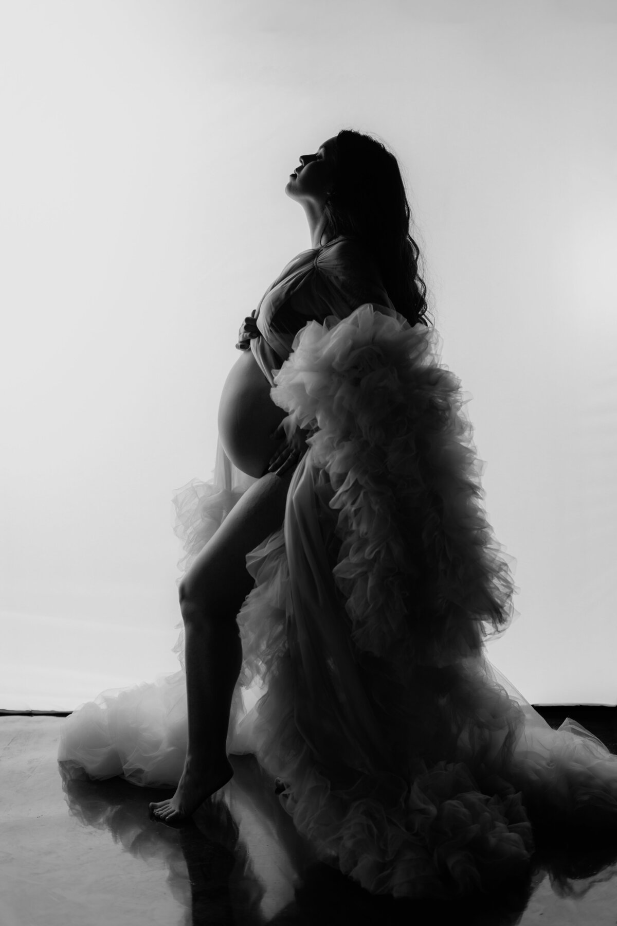 black and white maternity photo of a woman in a glamorous tulle maternity robe
