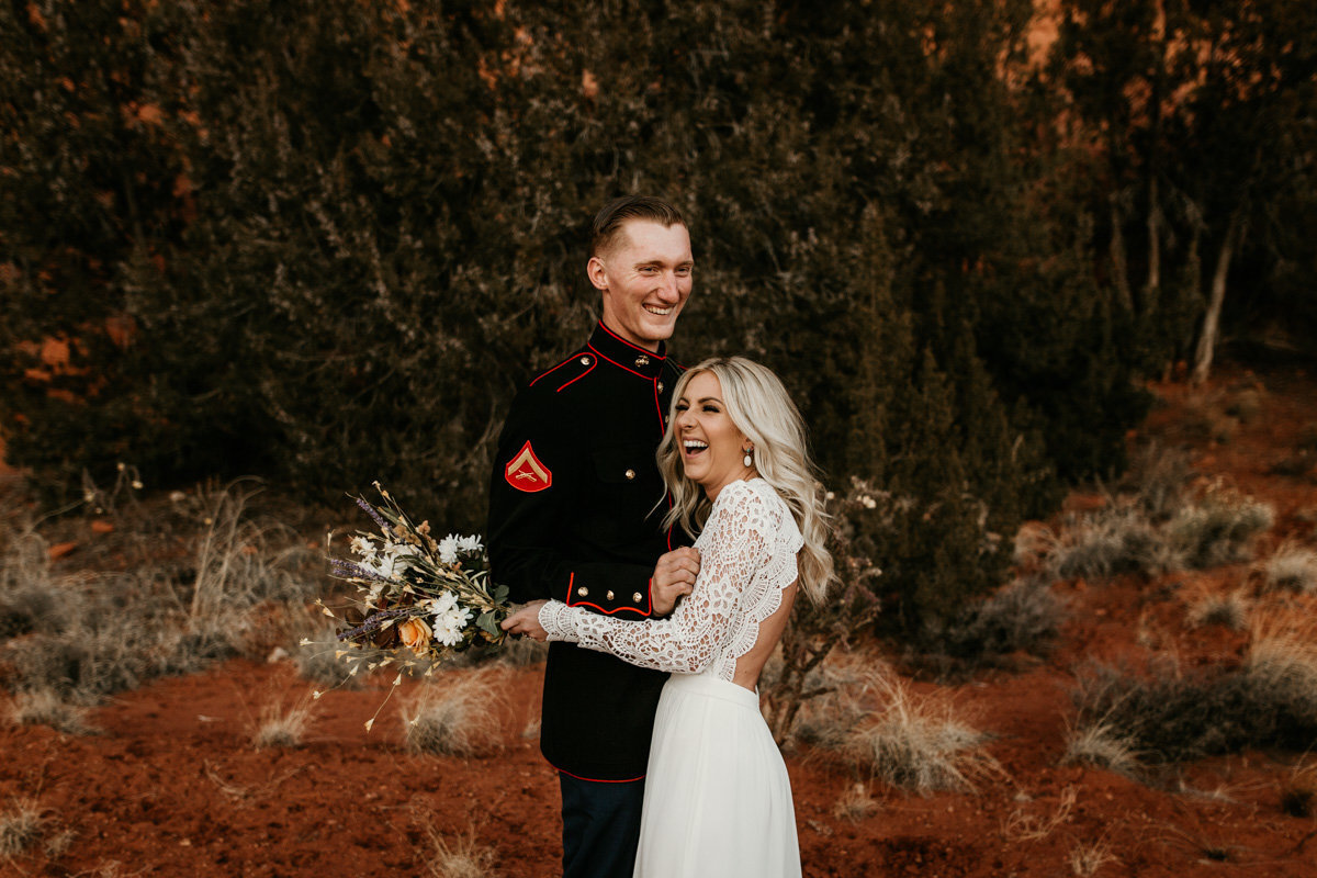 husband and wife hugging and laughing in the desert