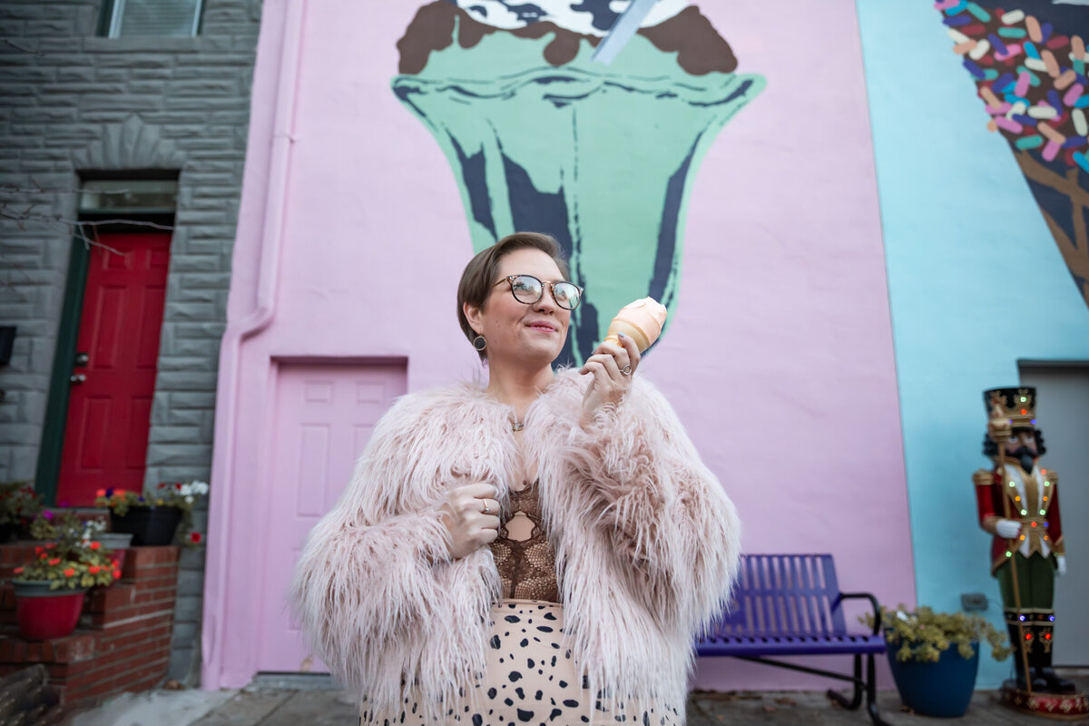 A creative entrepreneur smiles while eating ice cream in Baltimore, Maryland