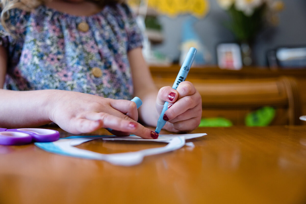 Small girl draws with marker on a piece of paper 