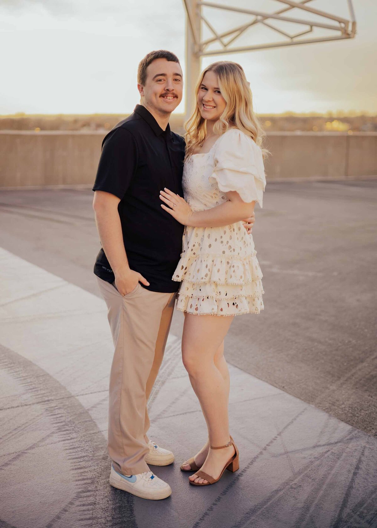 Maddie Rae Photography couple on the top of a parking garage standing side by side smiling at the camera.