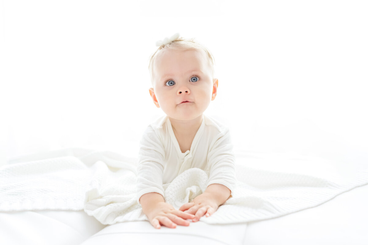 Baby and child photographer in Chandler, AZ tummy time with baby with big blue eyes