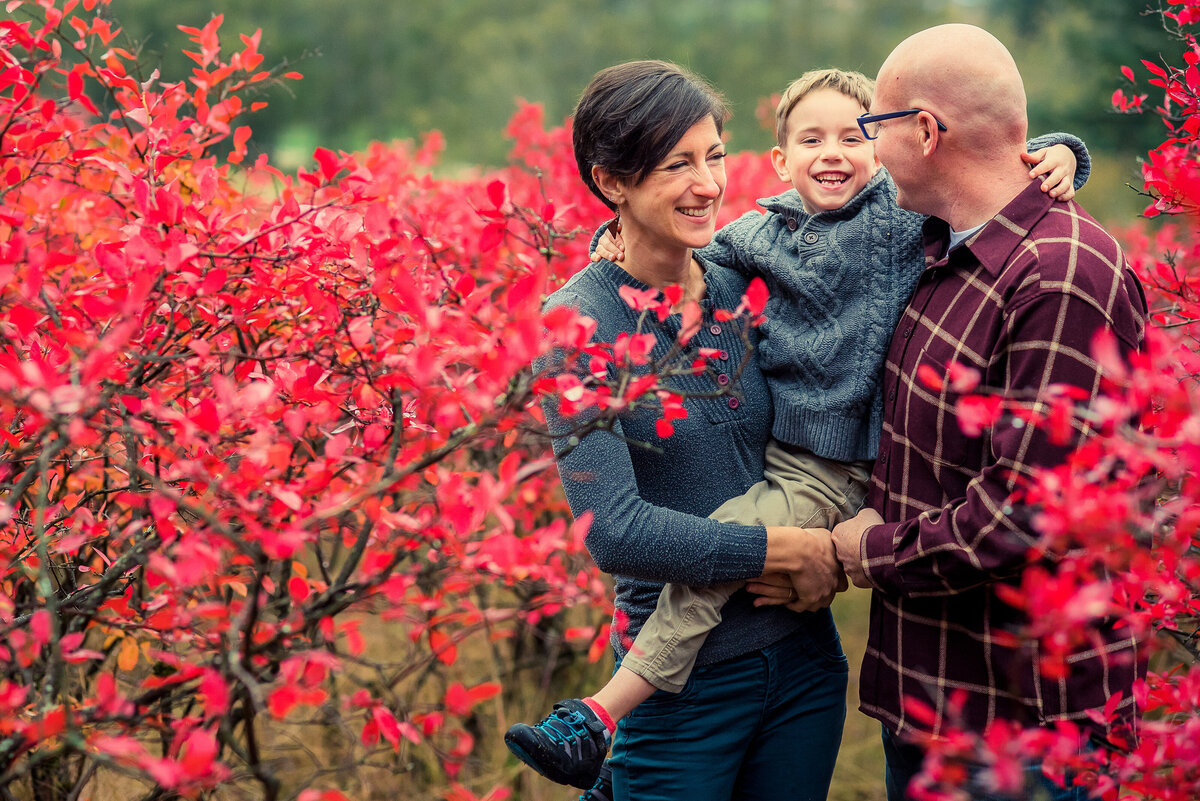 mom dad and son in red leaves