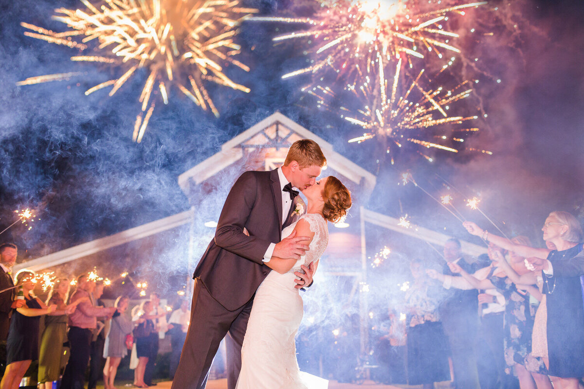 bride and groom kissing under fireworks at 9 oaks farm