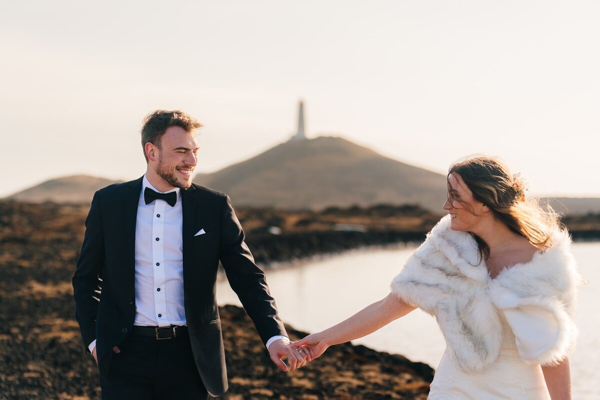 With genuine affection, the couple gazes into each other's eyes, framed by the charming presence of a lighthouse in the background. A perfect blend of love and scenic beauty.