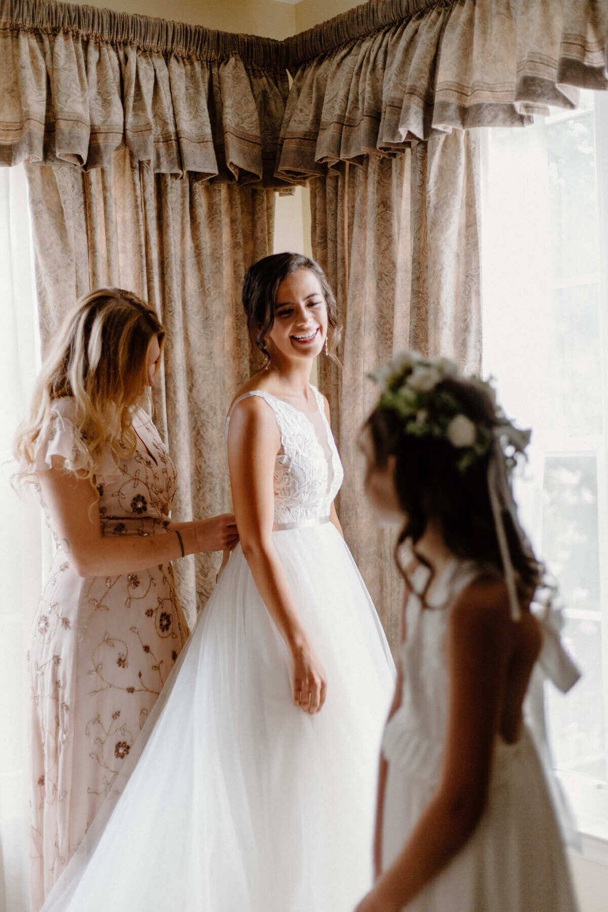 3-kara-loryn-photography-bride-putting-her-wedding-dress-on
