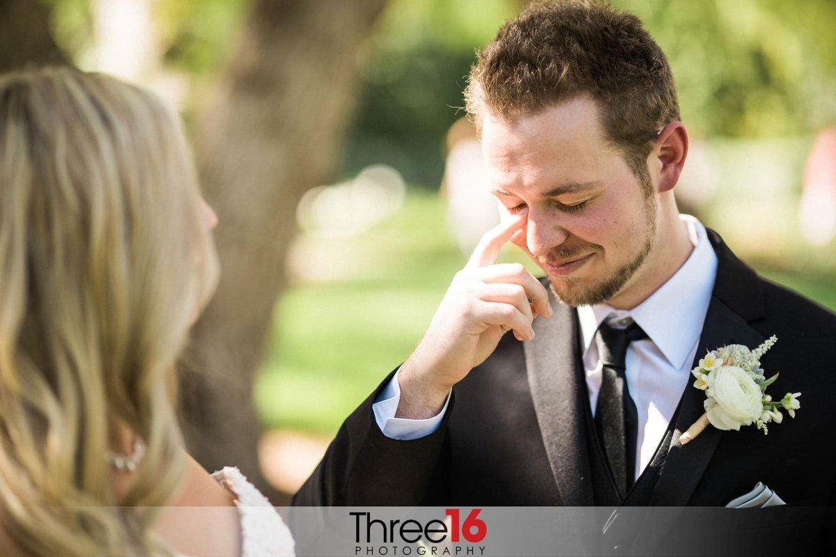 Groom wipes away his tear as he stands in front of his Bride at the altar