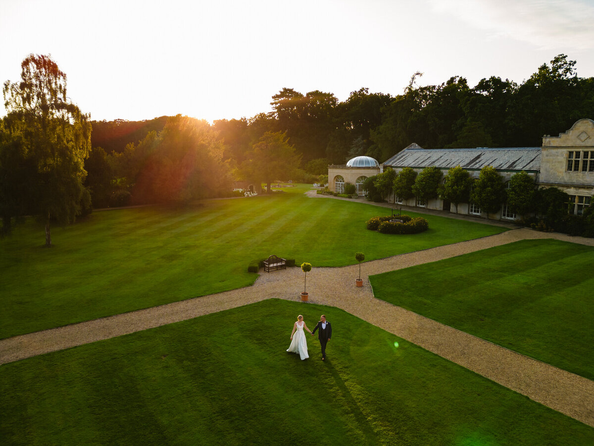 overhead shot of bride and groom walking through stapleford Park Hotel grounds on their wedding day