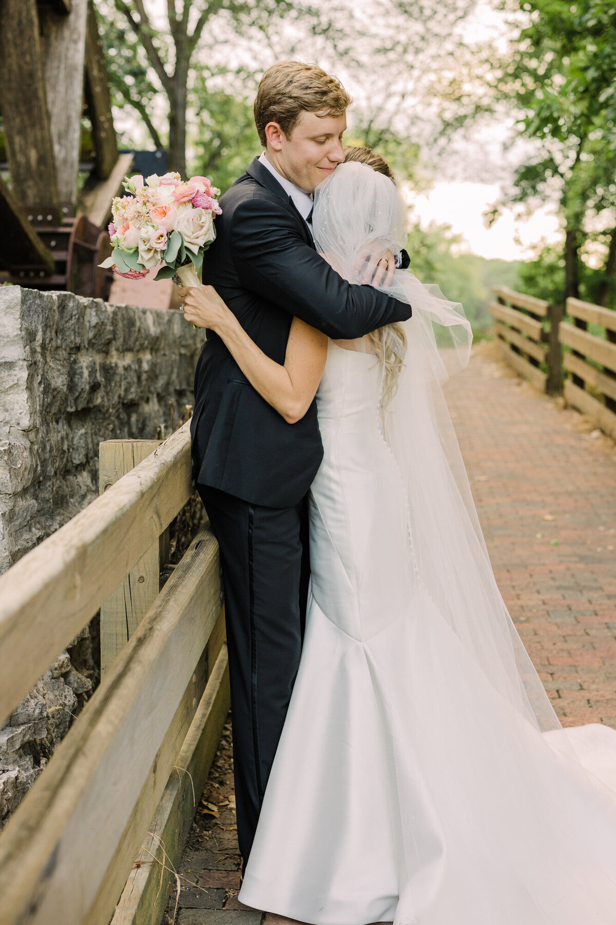 Newlyweds embrace on their wedding day as they take portraits at Graue Mill in Oak Brook