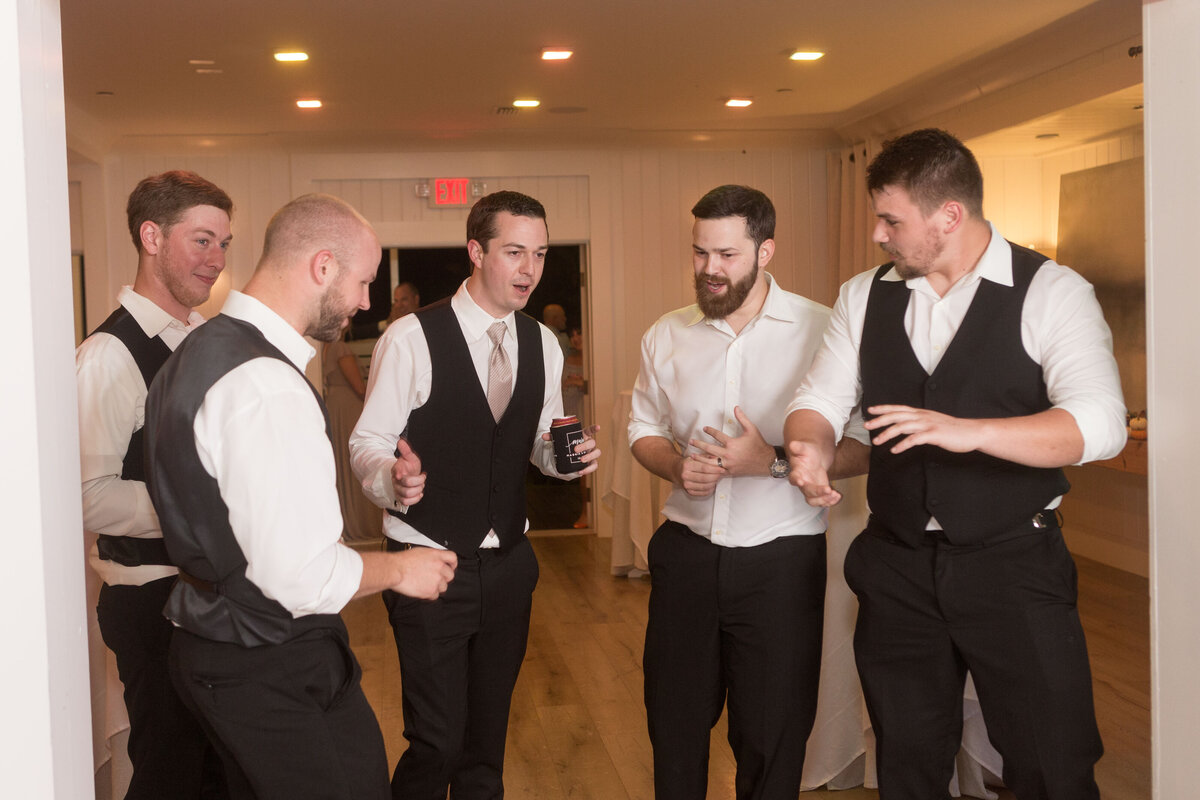 The groom and groomsmen cutting up at the wedding reception at Little Point Clear in Point Clear, Alabama.