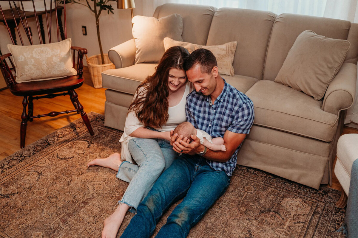 photo of man and woman sitting with newborn