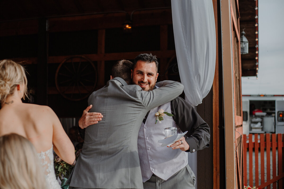 Two men hugging in gray suits