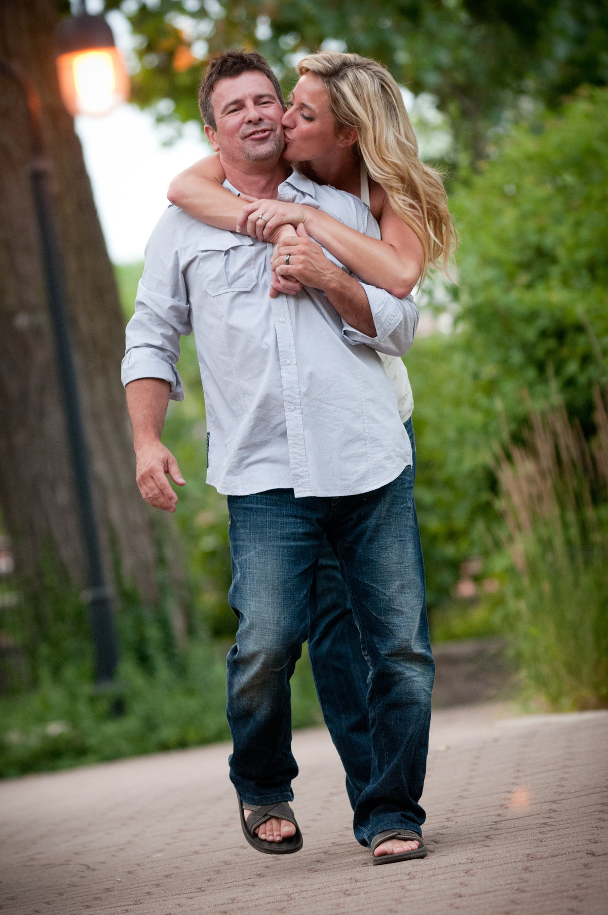 Engagement couple playfully walk along the Naperville River Walk