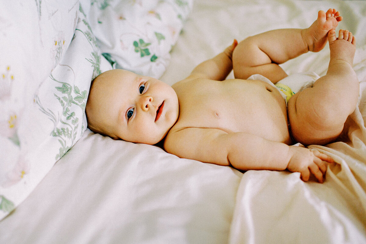 cute chubby healthy baby lies on a white sheets