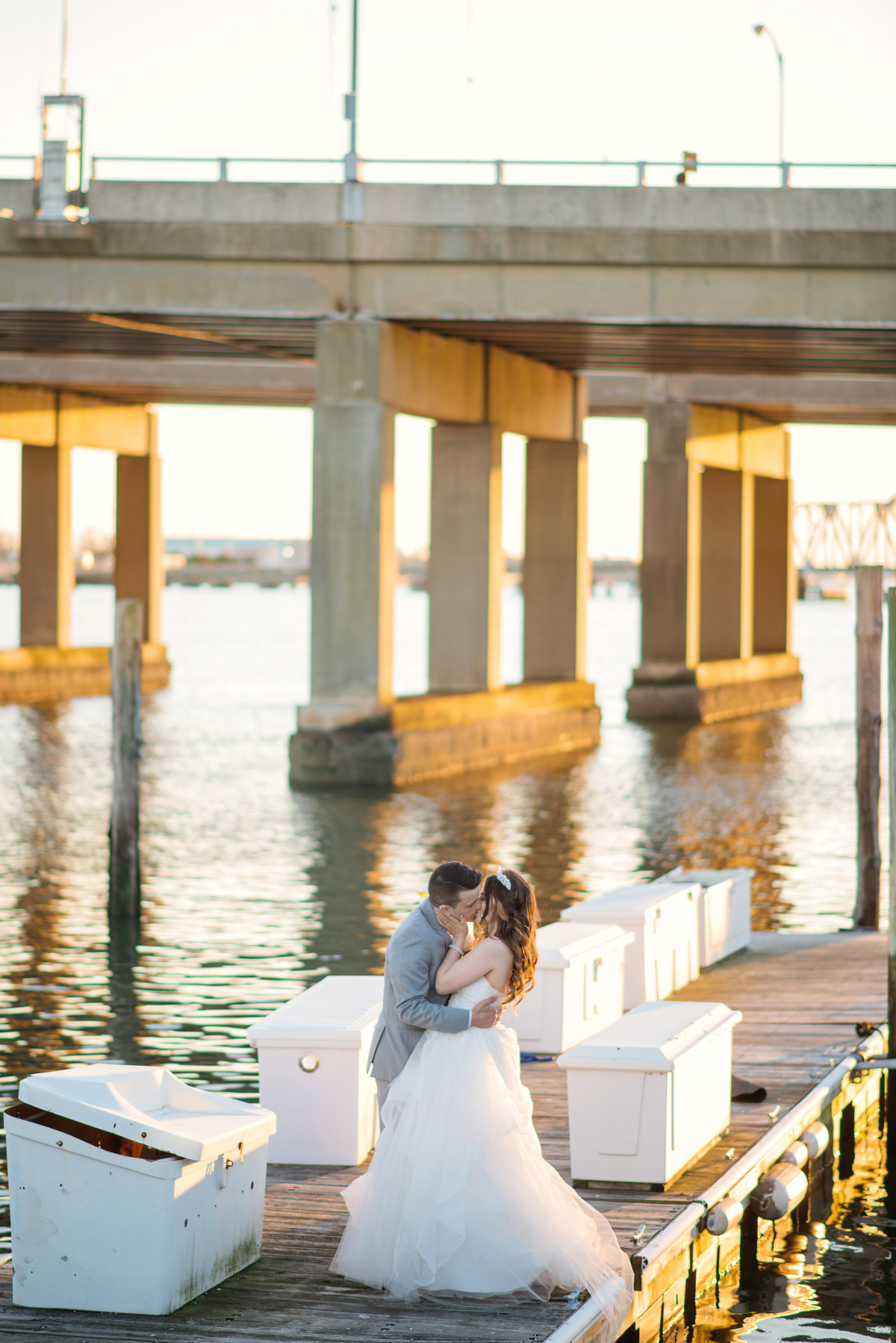 bride and groom kissing photo near water at bridgeview yacht club wedding