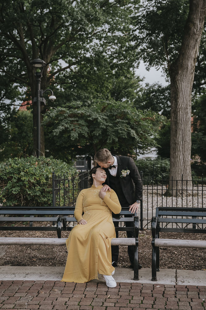 groom kissing bride in a yellow dress on the head