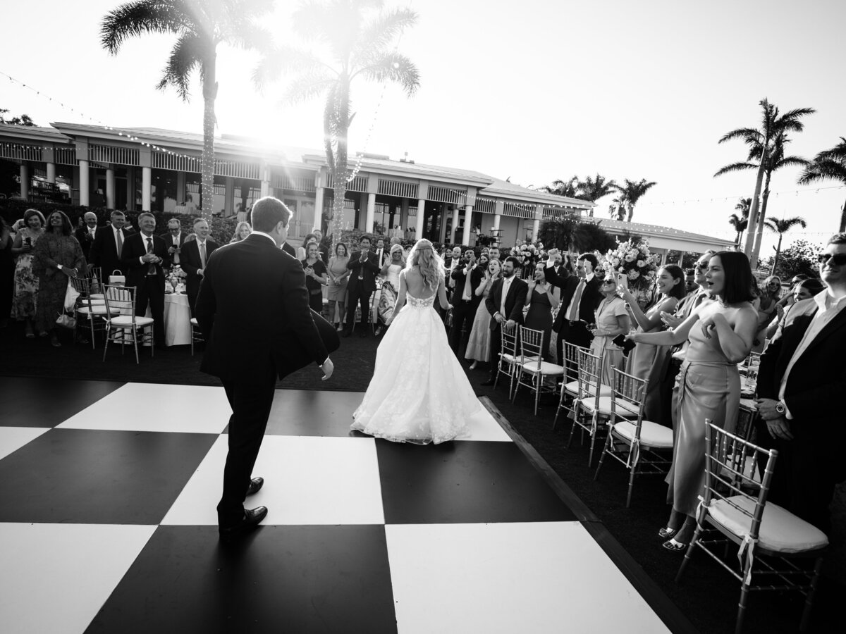 Bride and groom dancing on a black-and-white checkered floor during their wedding at the Resort at Longboat Key Club.