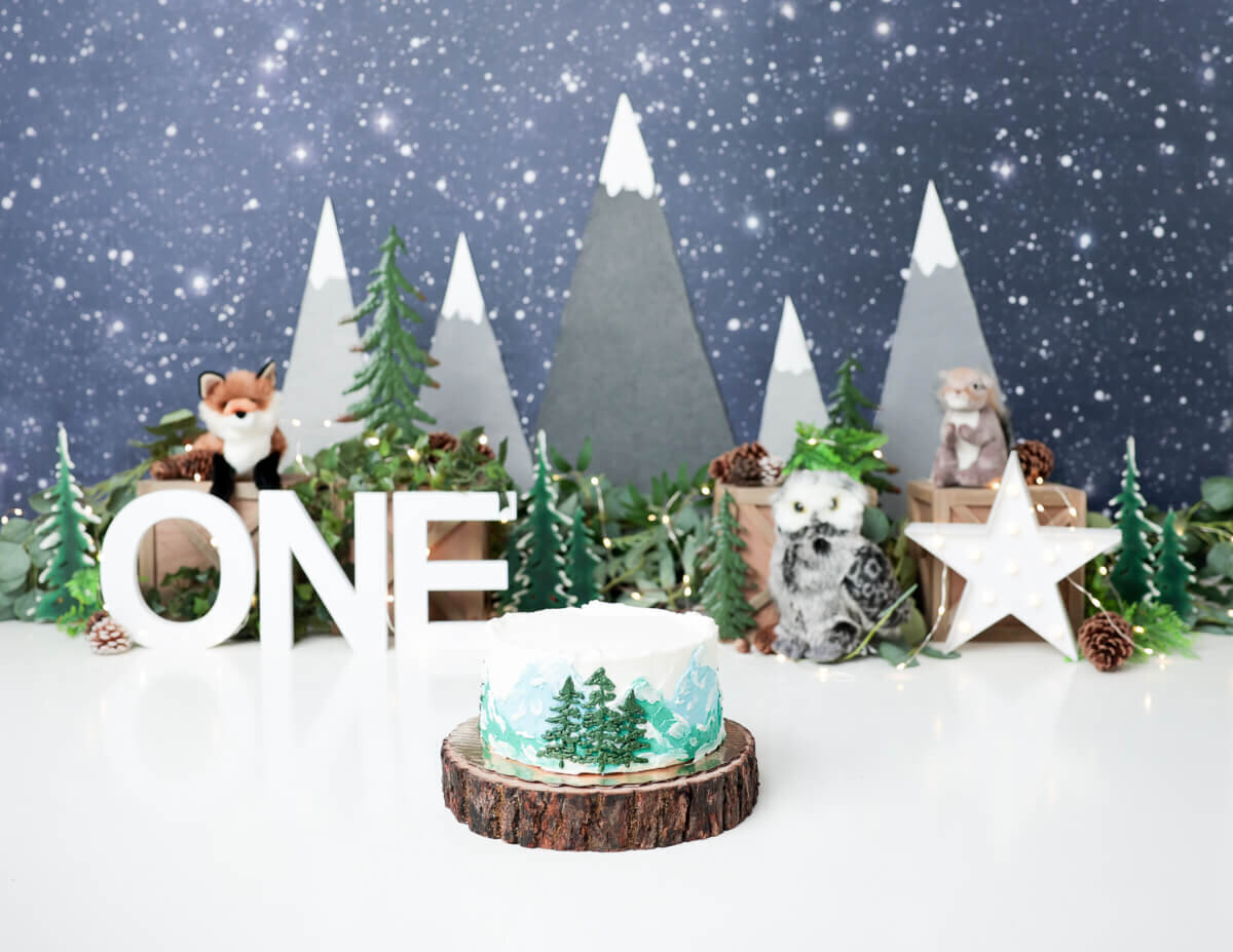 A nature-themed cake smash with a colorful cake amid vibrant outdoor scenery